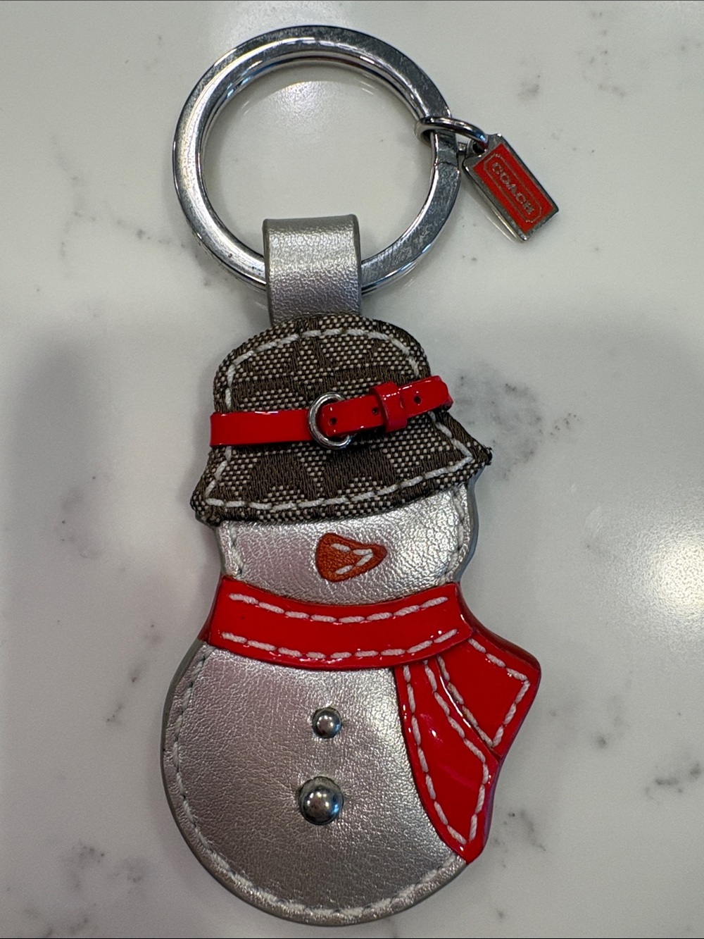 Coach Silver Snowman Keychain with Red Accents and Brown Hat